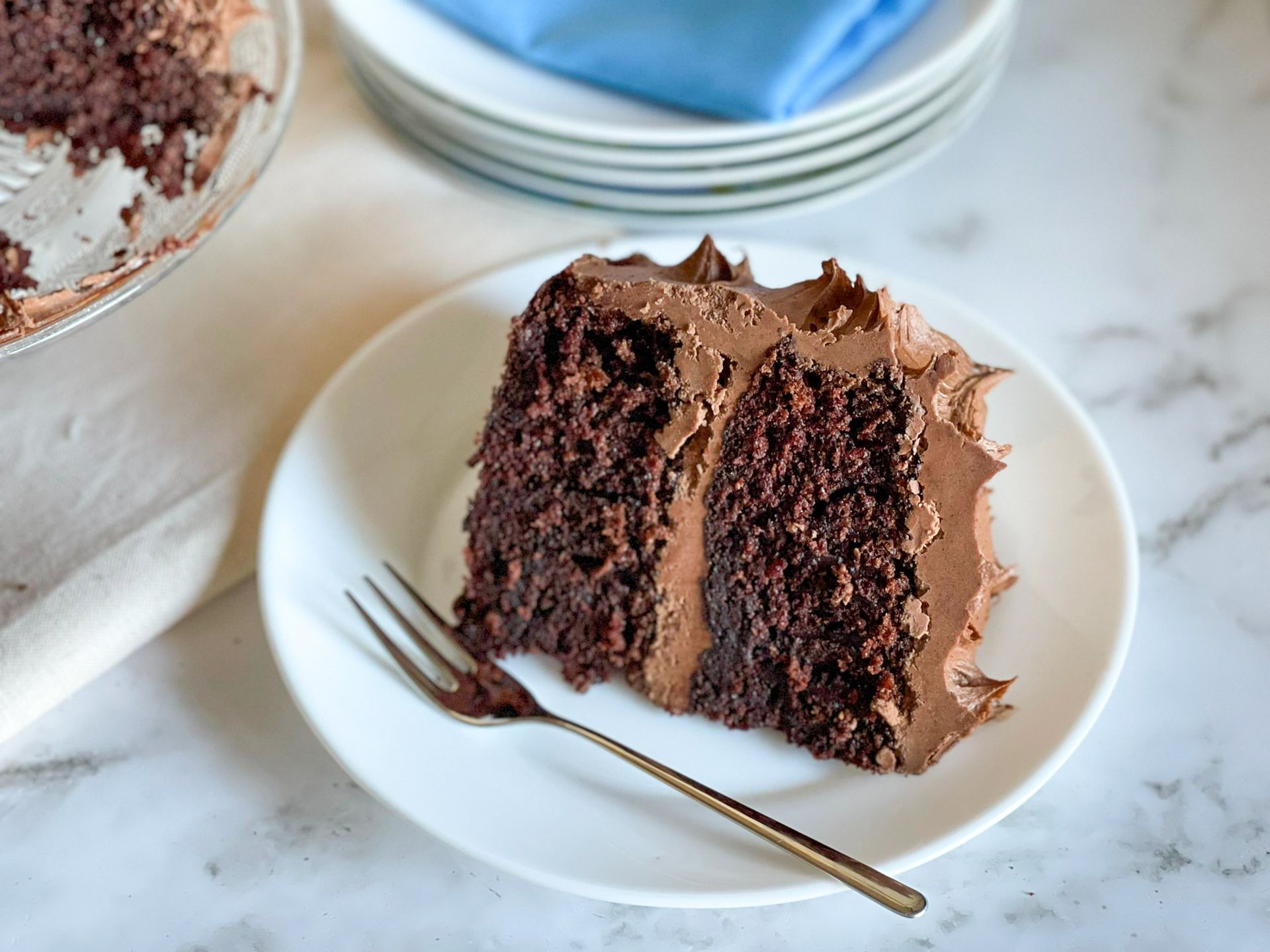 Una fetta di torta al cioccolato su un piatto bianco con una forchetta