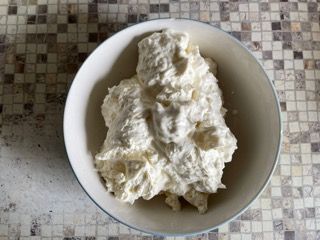 Una ciotola di panna montata è appoggiata su un tavolo.