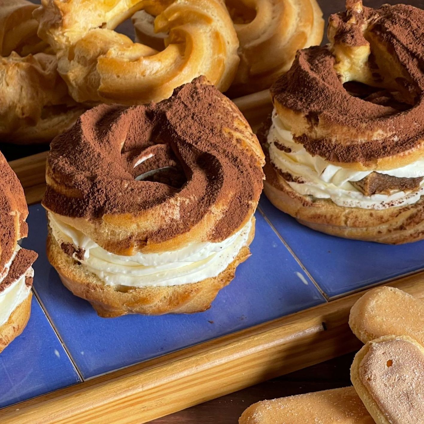 Un vassoio di pasticcini tra cui una ciambella al cioccolato con panna montata