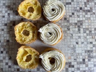 Tre ciambelle glassate sono appoggiate su un tavolo.