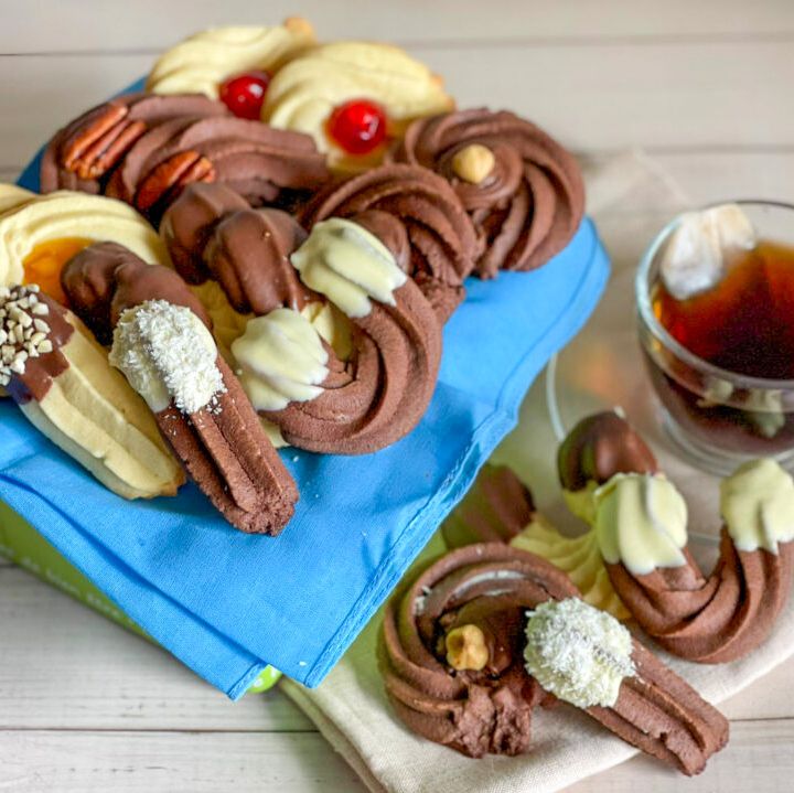 Un mucchio di biscotti su un panno blu accanto a una tazza di tè