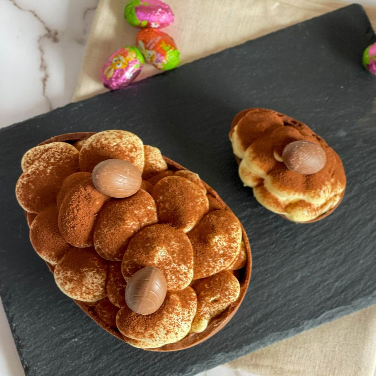 Un uovo di Pasqua al cioccolato ripieno di tiramisù e uova di cioccolato