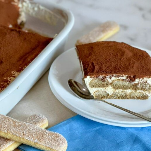 Fetta di tiramisù senza glutine che mostra gli strati perfetti di crema al mascarpone e savoiardi se