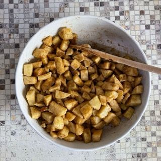 Una ciotola di cibo con un cucchiaio di legno dentro