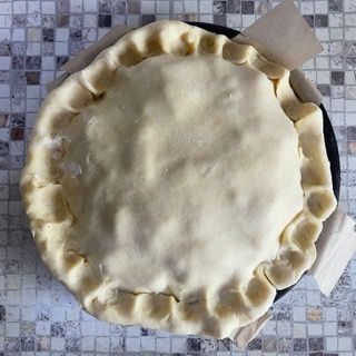 Una crosta di torta è appoggiata su un piatto su un tavolo