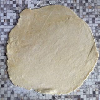 Un grande pezzo di pasta è appoggiato su un tavolo a scacchi