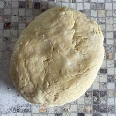 Una palla di pasta è appoggiata su un tavolo piastrellato.