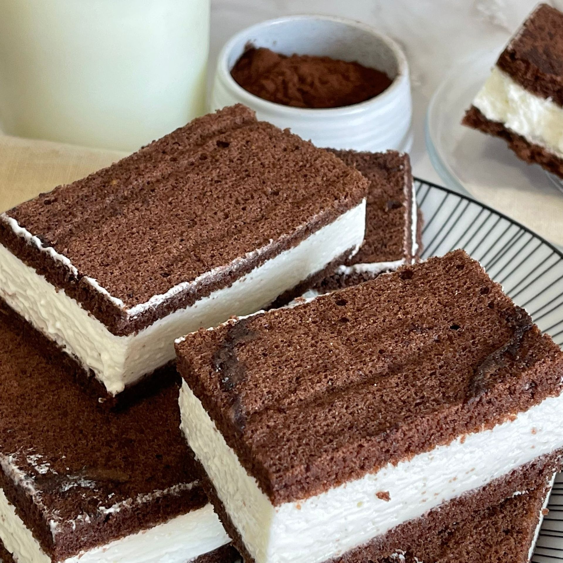 Una pila di sandwich al cioccolato e gelato bianco su un piatto.
