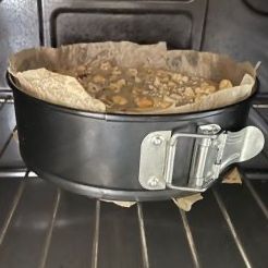 Una torta in una teglia è appoggiata sulla griglia del forno.