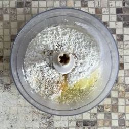 Un robot da cucina pieno di farina, olio e spezie.