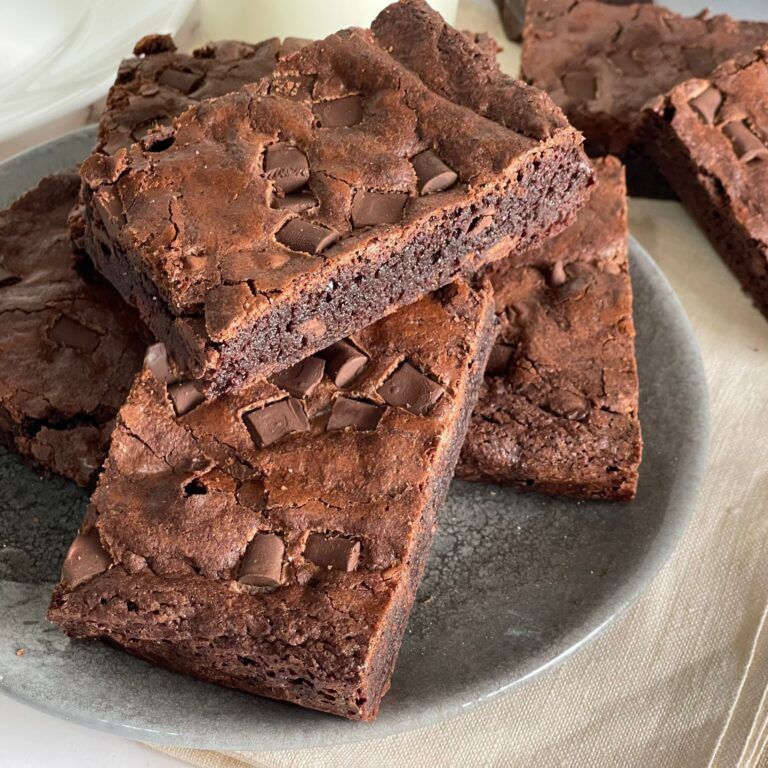 Un piatto di brownies con gocce di cioccolato su un tavolo.