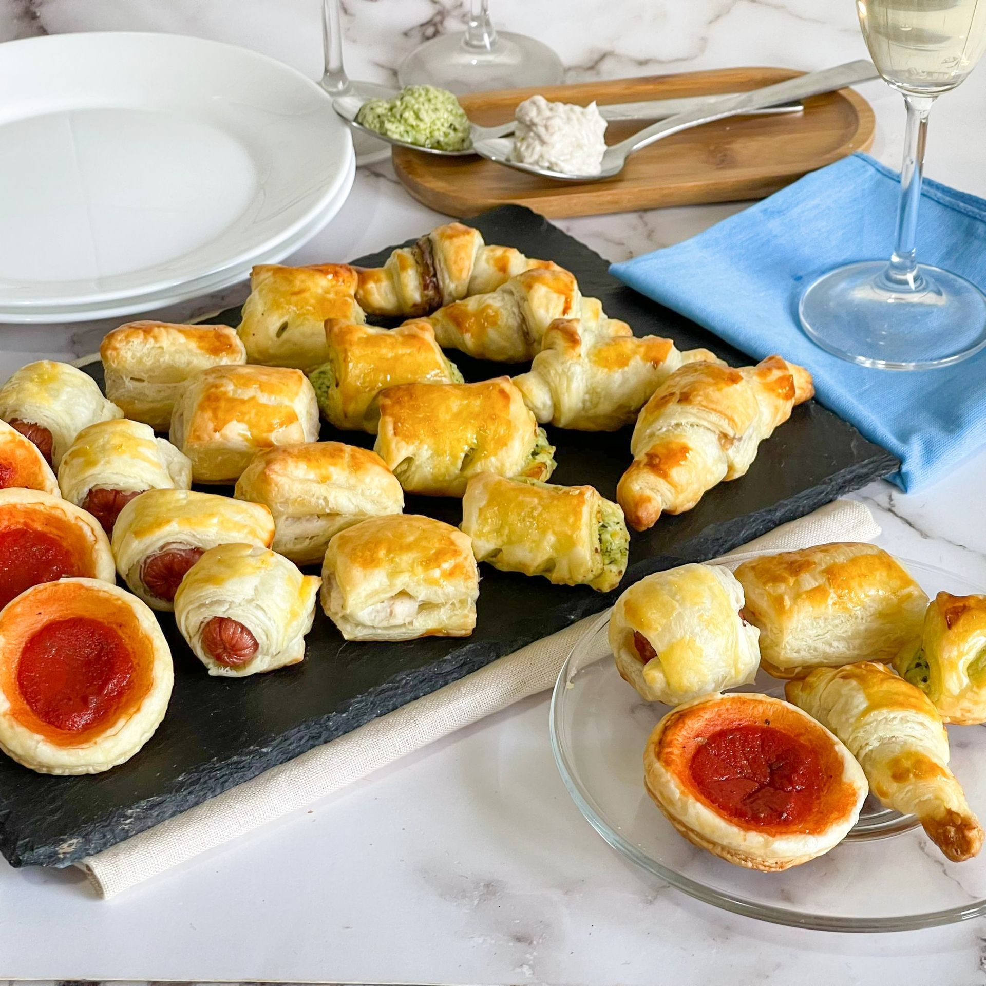 Un tavolo sormontato da piatti di cibo e bicchieri di vino.