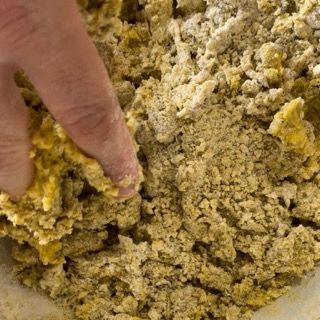 La mano di una persona sta infilando la mano in una ciotola di cibo.