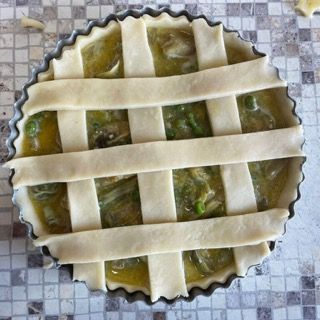 Una torta con una crosta a traliccio è appoggiata su un tavolo