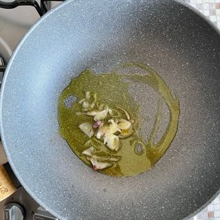 Una padella piena di olio e aglio sul fornello.