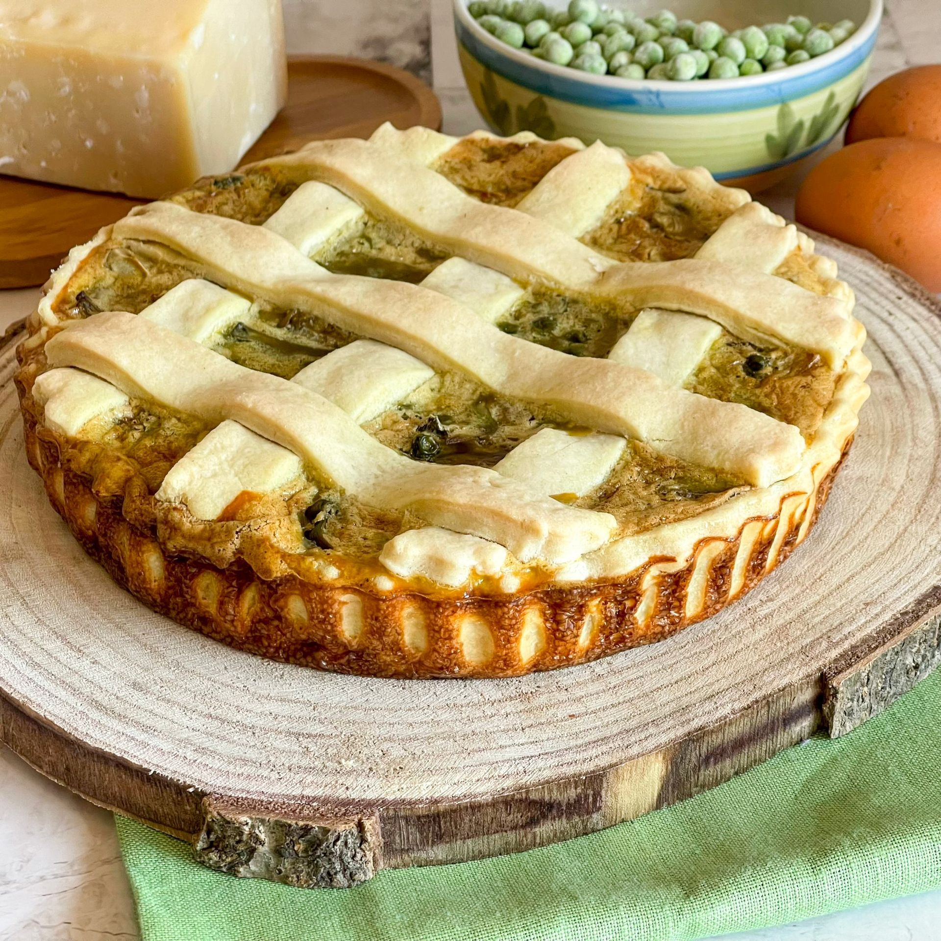 Una torta con una crosta a reticolo è appoggiata su un tagliere di legno.