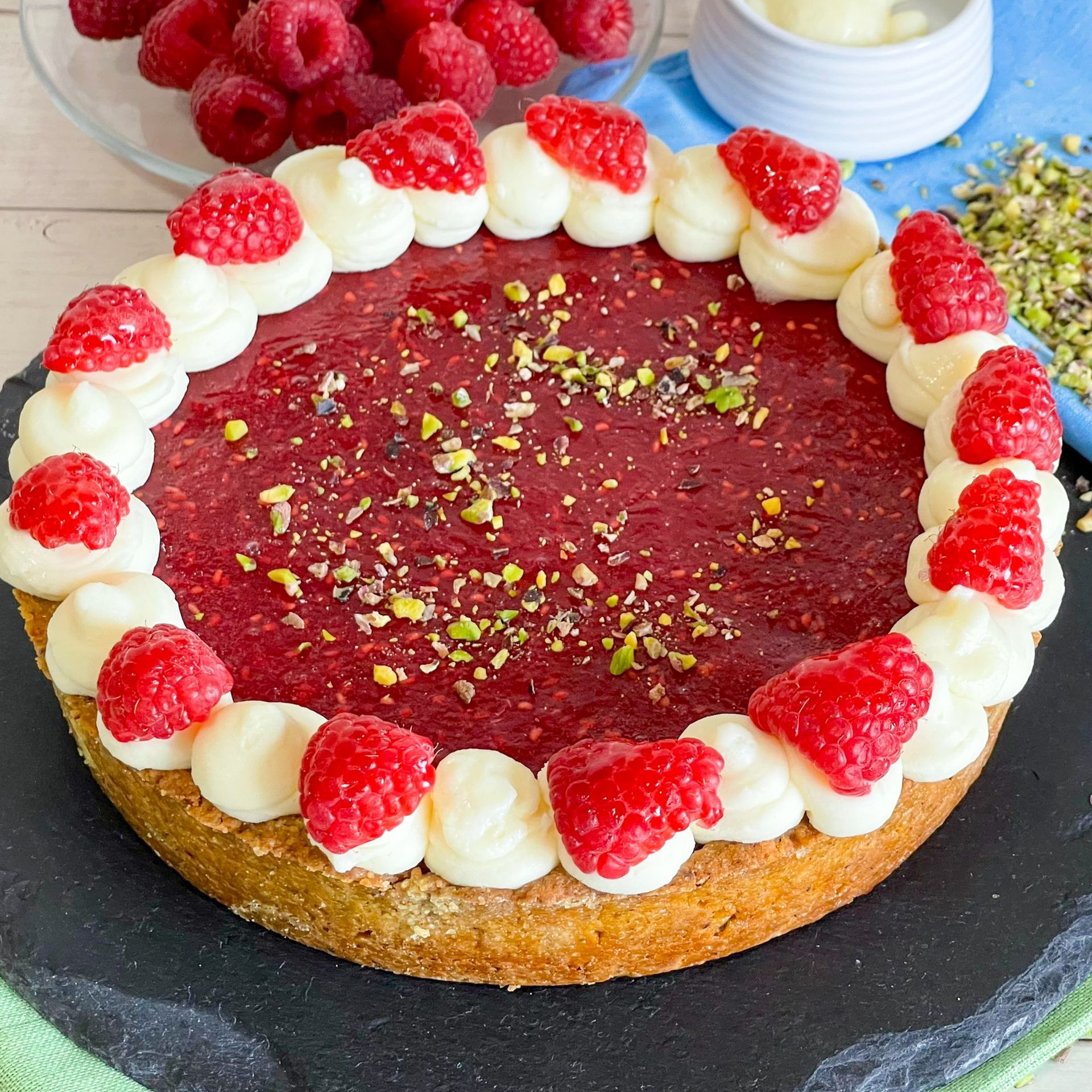 Una torta con lamponi e panna montata sopra