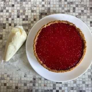 Una torta su un piatto bianco accanto a un sacchetto di glassa