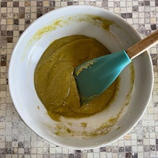 Una ciotola bianca con una spatola verde dentro