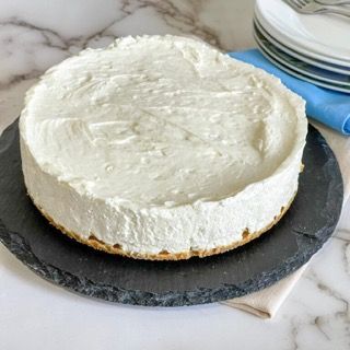 Una cheesecake è appoggiata su un piatto nero su un tavolo