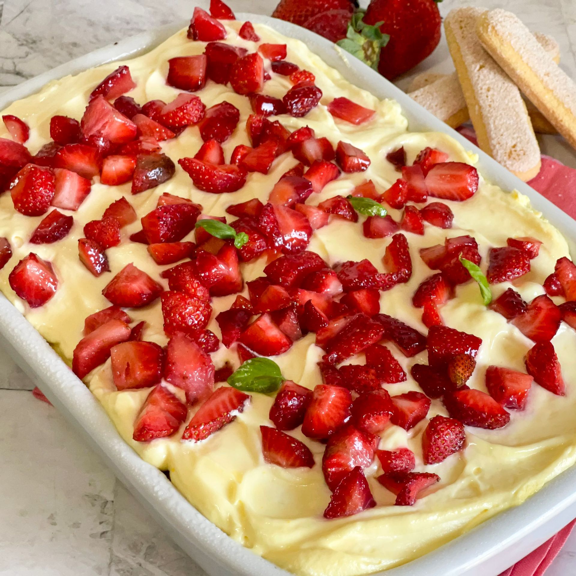 Una teglia piena di fragole e panna montata.