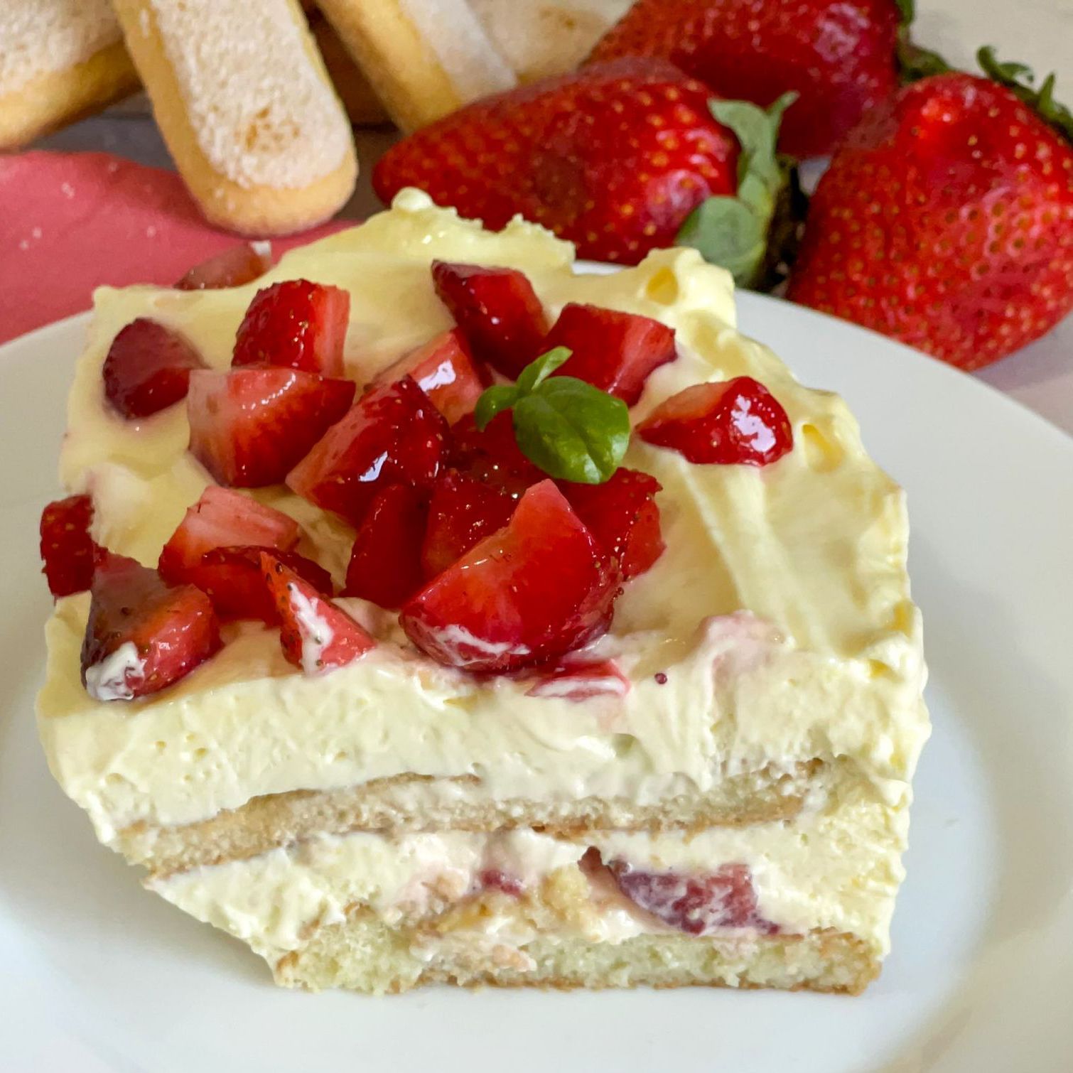 Una fetta di torta con fragole sopra su un piatto bianco