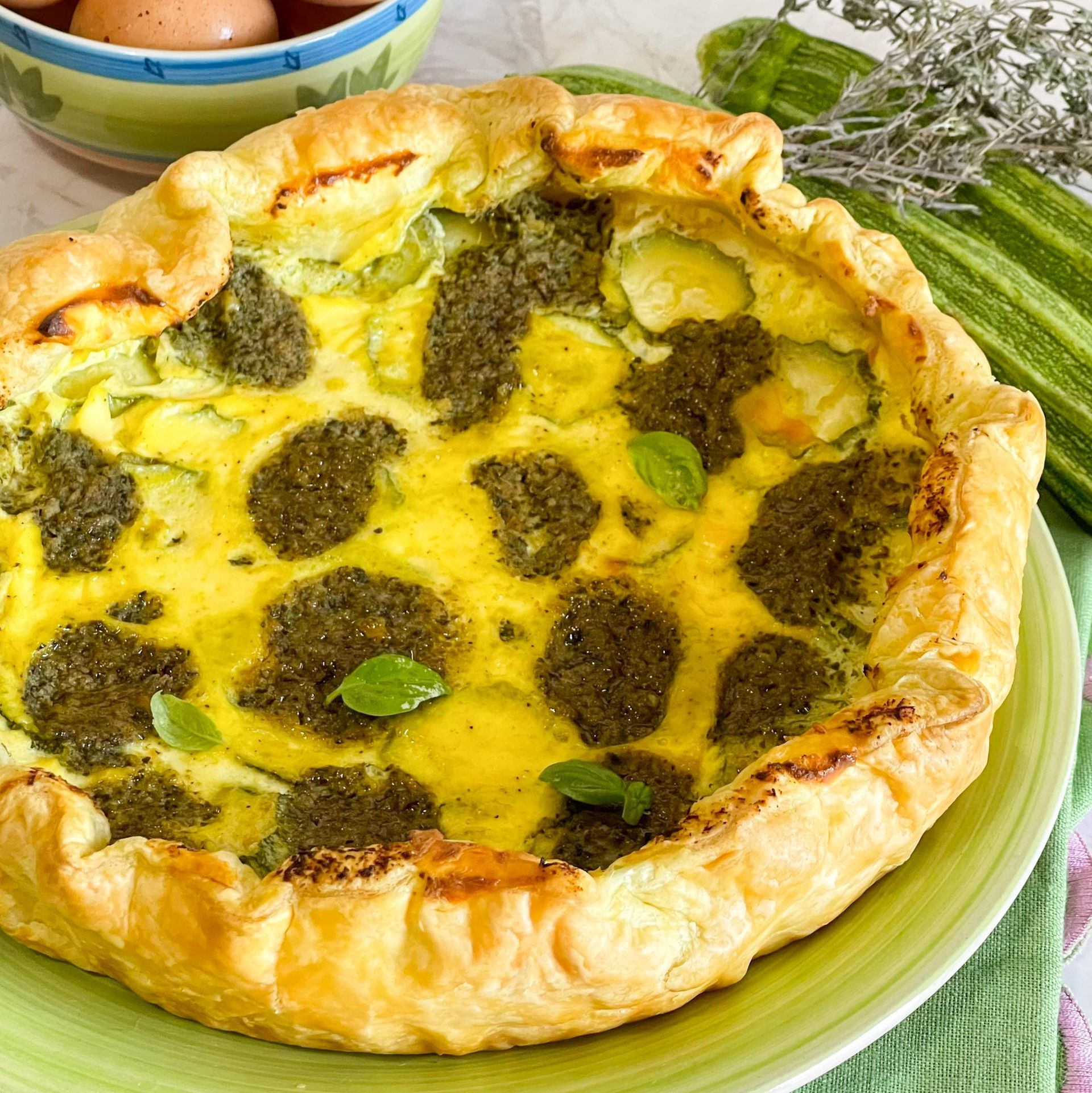 Un primo piano di una quiche su un piatto verde