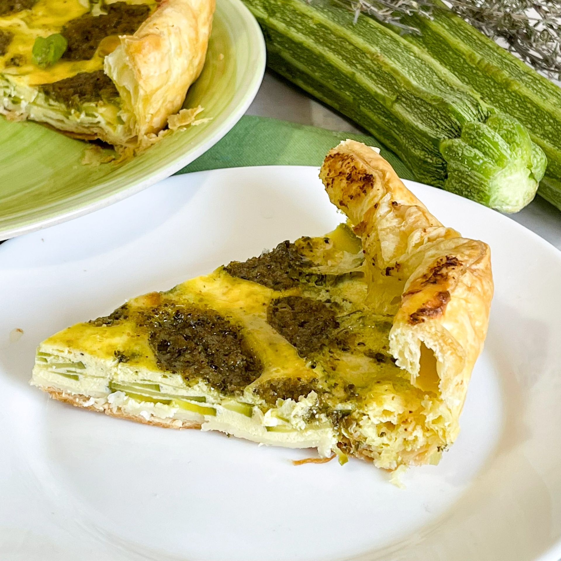 Una fetta di quiche su un piatto bianco con un morso preso