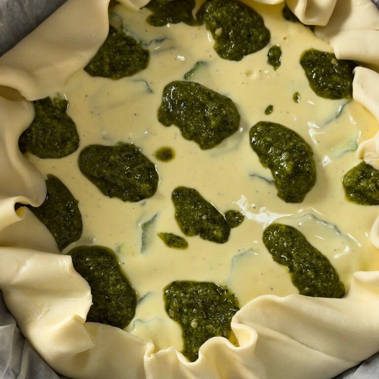 Un primo piano di una torta con salsa verde sopra