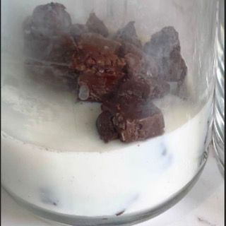 Un barattolo di vetro pieno di yogurt e gocce di cioccolato.