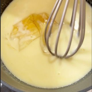 Un primo piano di una frusta in una ciotola di liquido