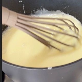 Una frusta di legno è in una pentola di liquido
