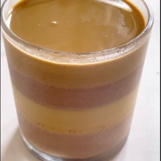 Un primo piano di un bicchiere pieno di un liquido marrone
