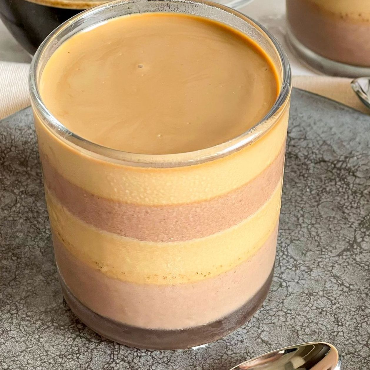 Un primo piano di un bicchiere di caffè con un cucchiaino dentro.