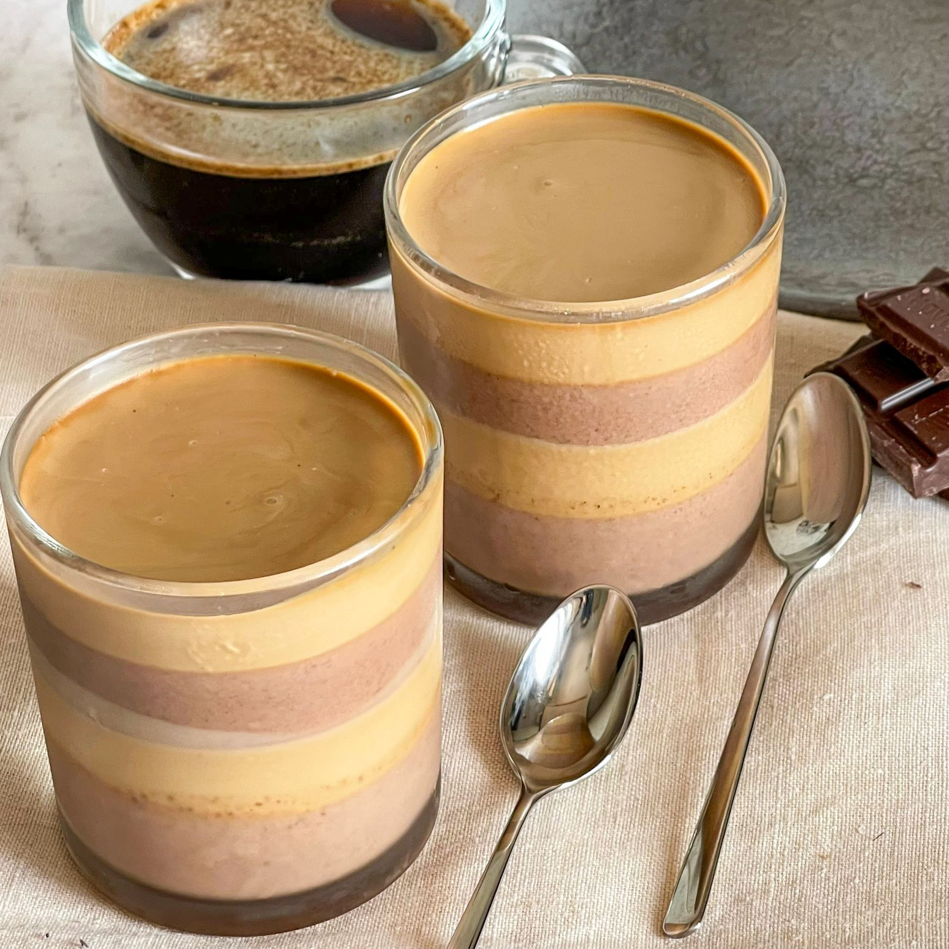 Due tazze di caffè e due cucchiai su un tavolo.