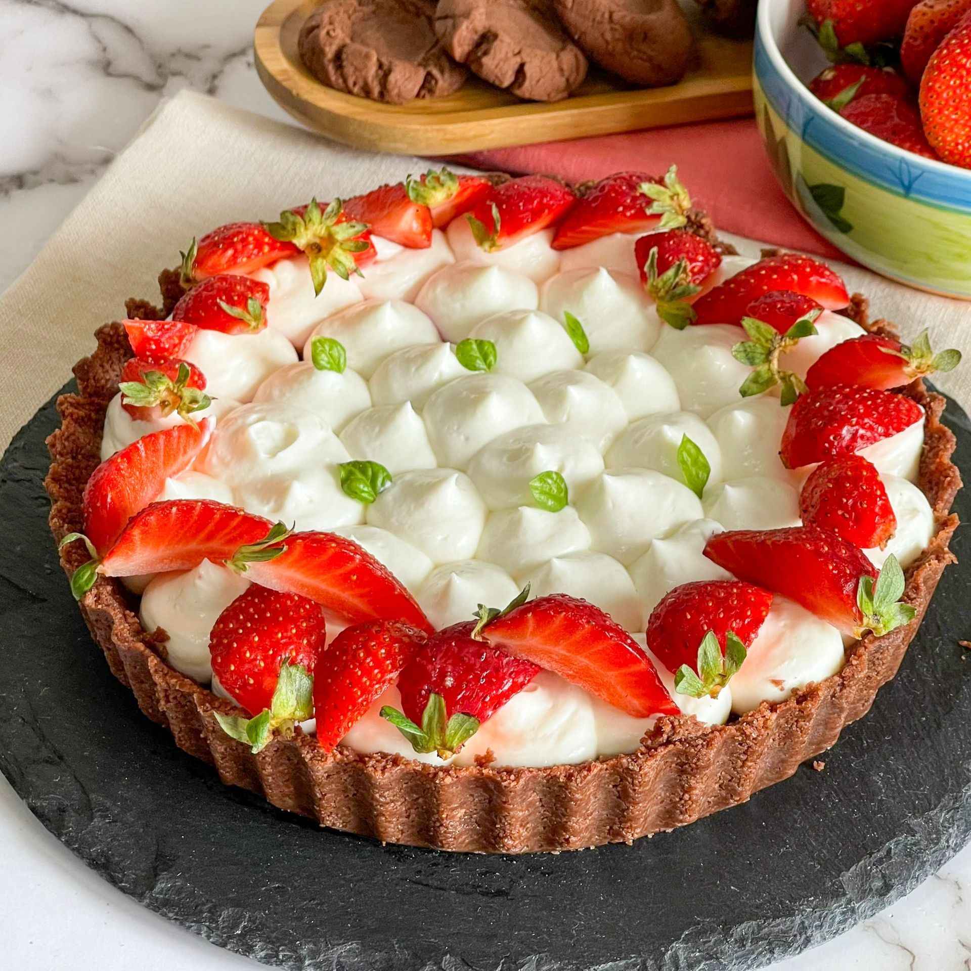 Una torta con fragole e panna montata sopra