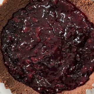 Un primo piano di una crosta di torta farcita con salsa di frutti di bosco