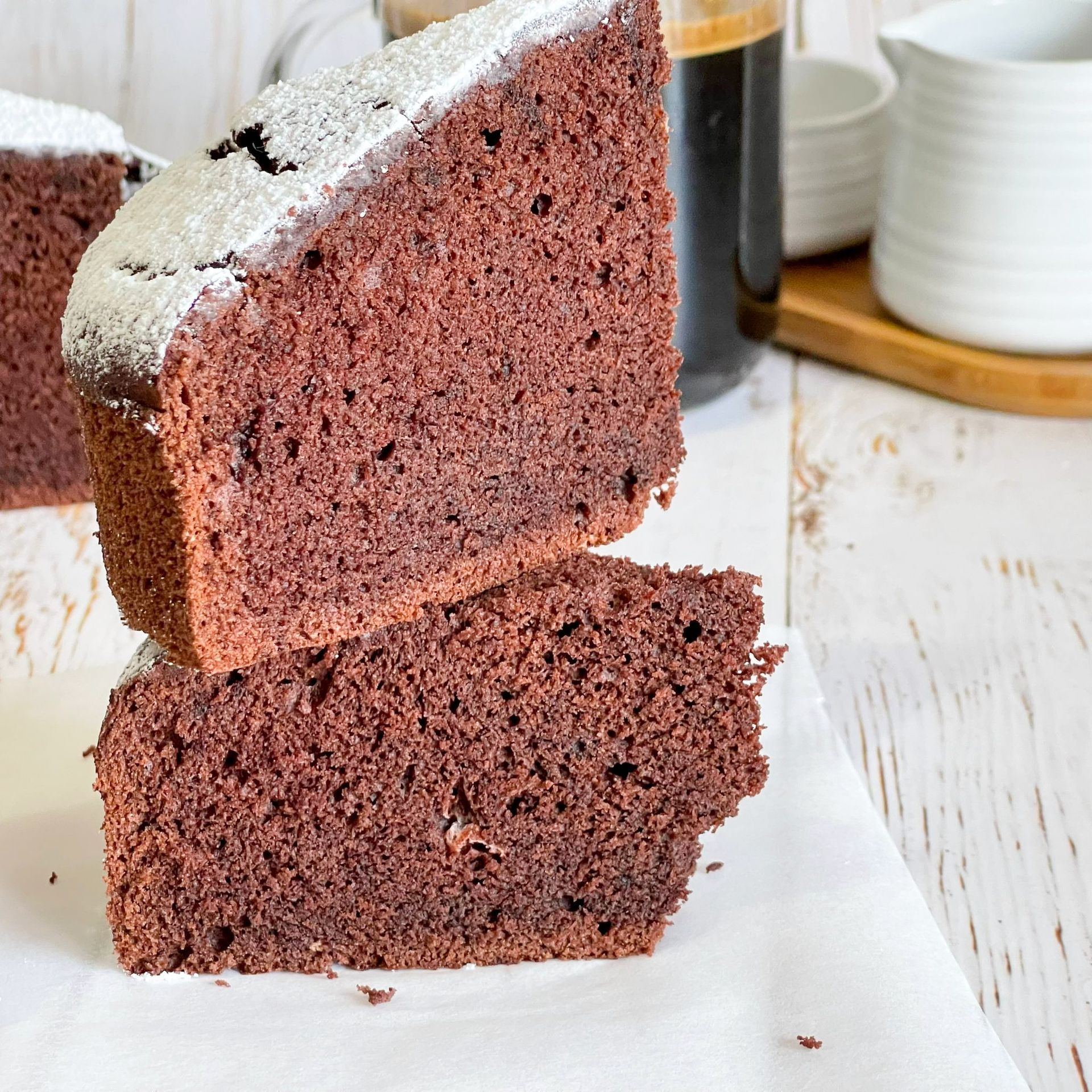 Due fette di torta al cioccolato sono impilate una sopra l'altra su un tavolo.