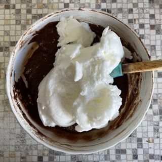 Una ciotola di cioccolato e panna montata con una spatola