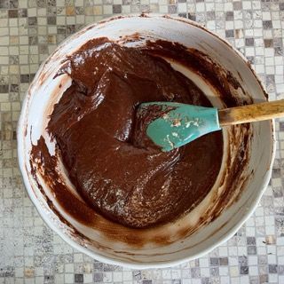 Una ciotola di impasto al cioccolato con una spatola dentro