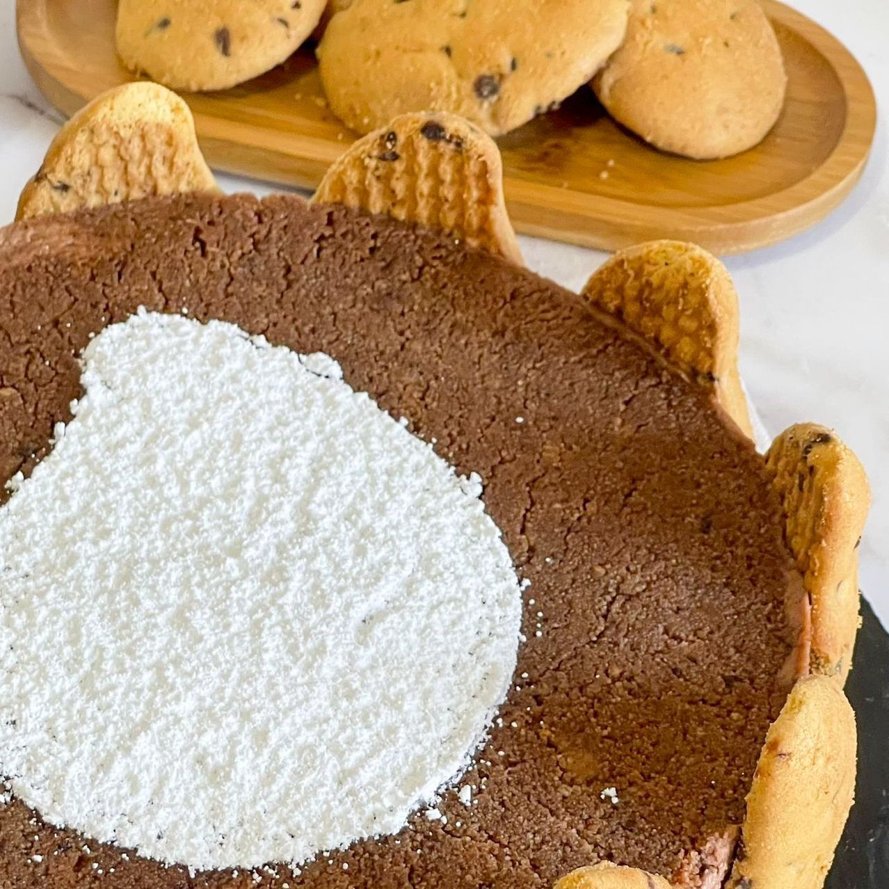 Un primo piano di una torta al cioccolato con zucchero a velo sopra.