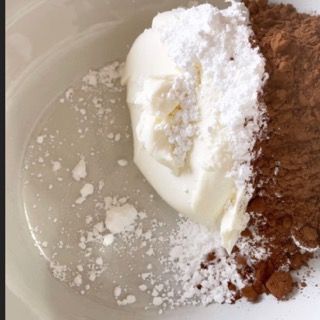 Una ciotola bianca piena di zucchero a velo e cacao in polvere