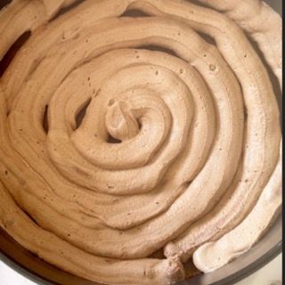 Un primo piano di un vortice di glassa al cioccolato in una ciotola