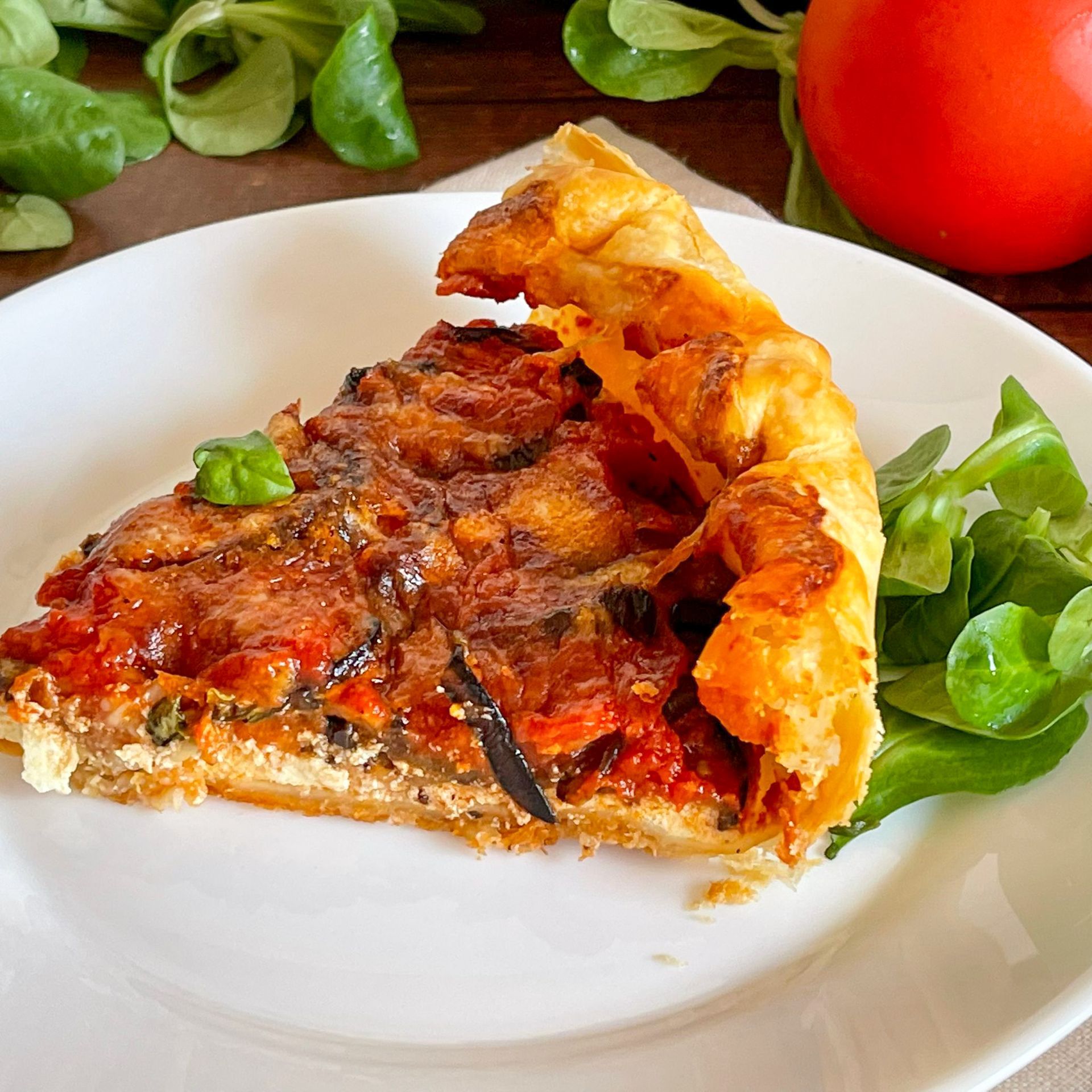 Una fetta di pizza su un piatto bianco con lattuga