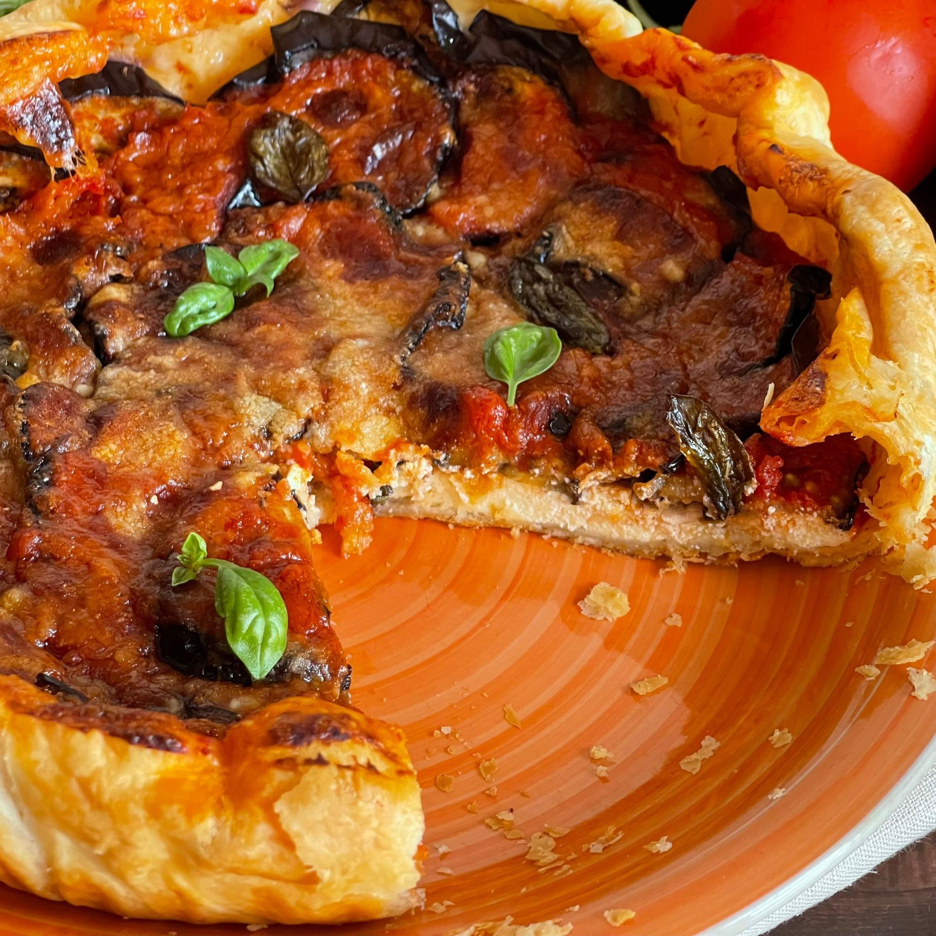 Una pizza con una fetta tolta su un piatto arancione