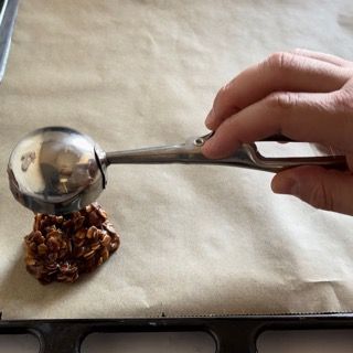 Una persona tiene un cucchiaio sopra una pila di noci