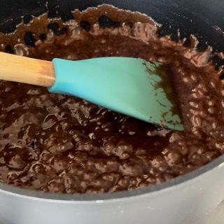 Una pentola di salsa al cioccolato con una spatola dentro