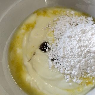 Una ciotola di yogurt con zucchero a velo sopra