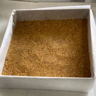 Una scatola bianca piena di briciole marroni su un tavolo