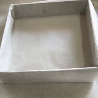 Una scatola di cartone vuota è appoggiata su un tavolo.